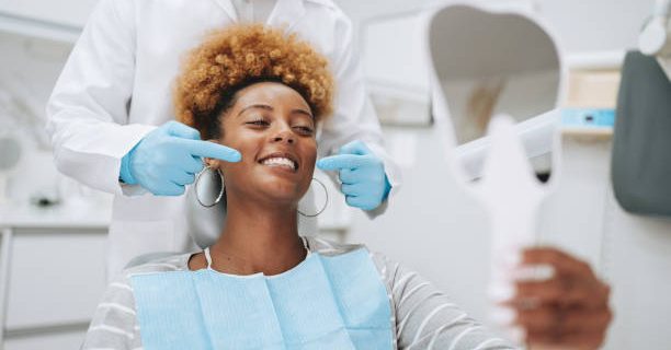 Woman at dentist holding mirror